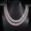 Two-tone iced out Cuban link chains with sparkling stones on a black jewelry bust display