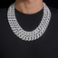 Layered iced-out Cuban link chain necklace with sparkling stones on black shirt