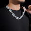 Man wearing a silver iced-out chain necklace with blue and pink gemstone accents
