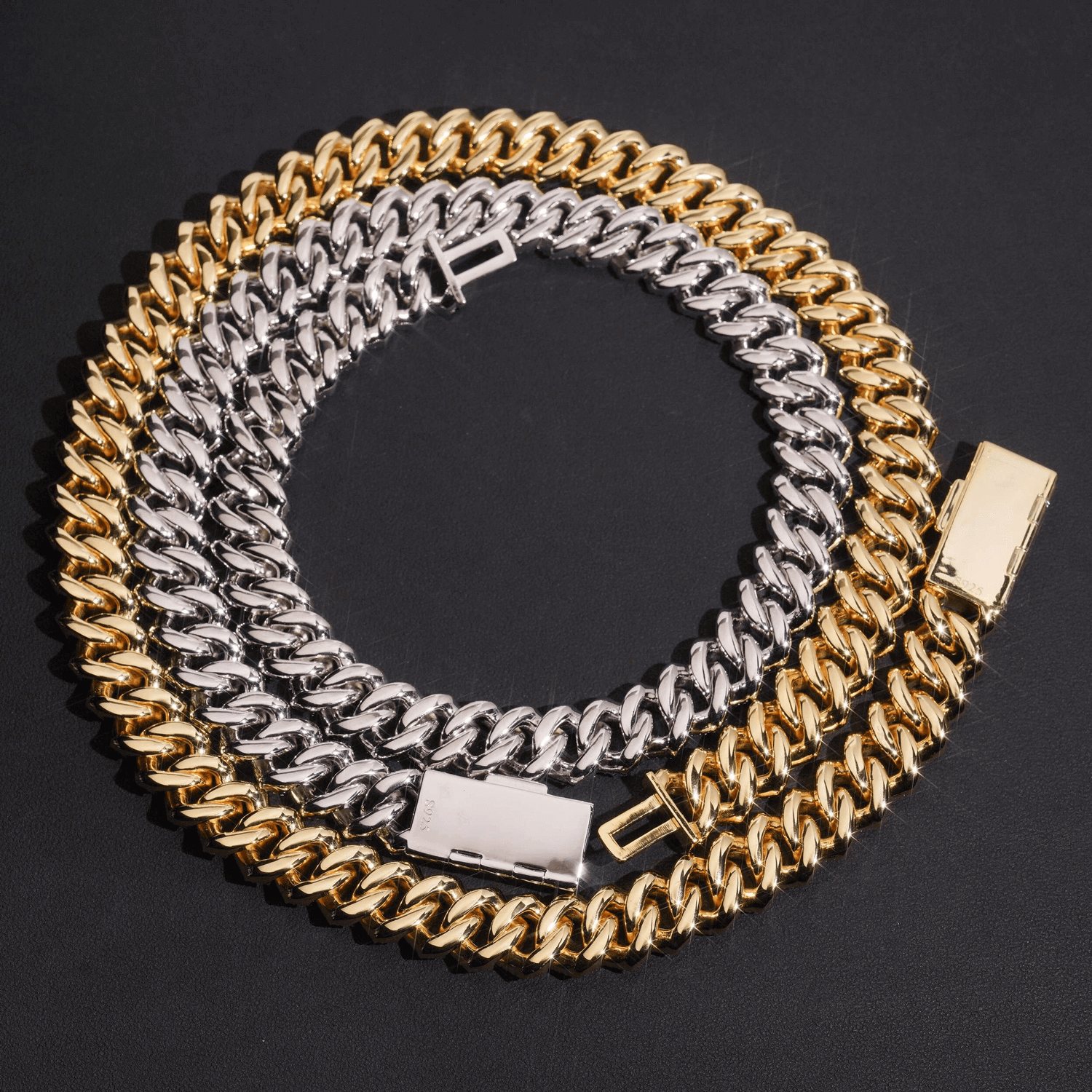 Gold and silver Cuban link chain necklaces with box clasps on a black background