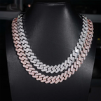 Two-tone iced out Cuban link chains with sparkling stones on a black jewelry bust display