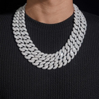Layered iced-out Cuban link chain necklace with sparkling stones on black shirt