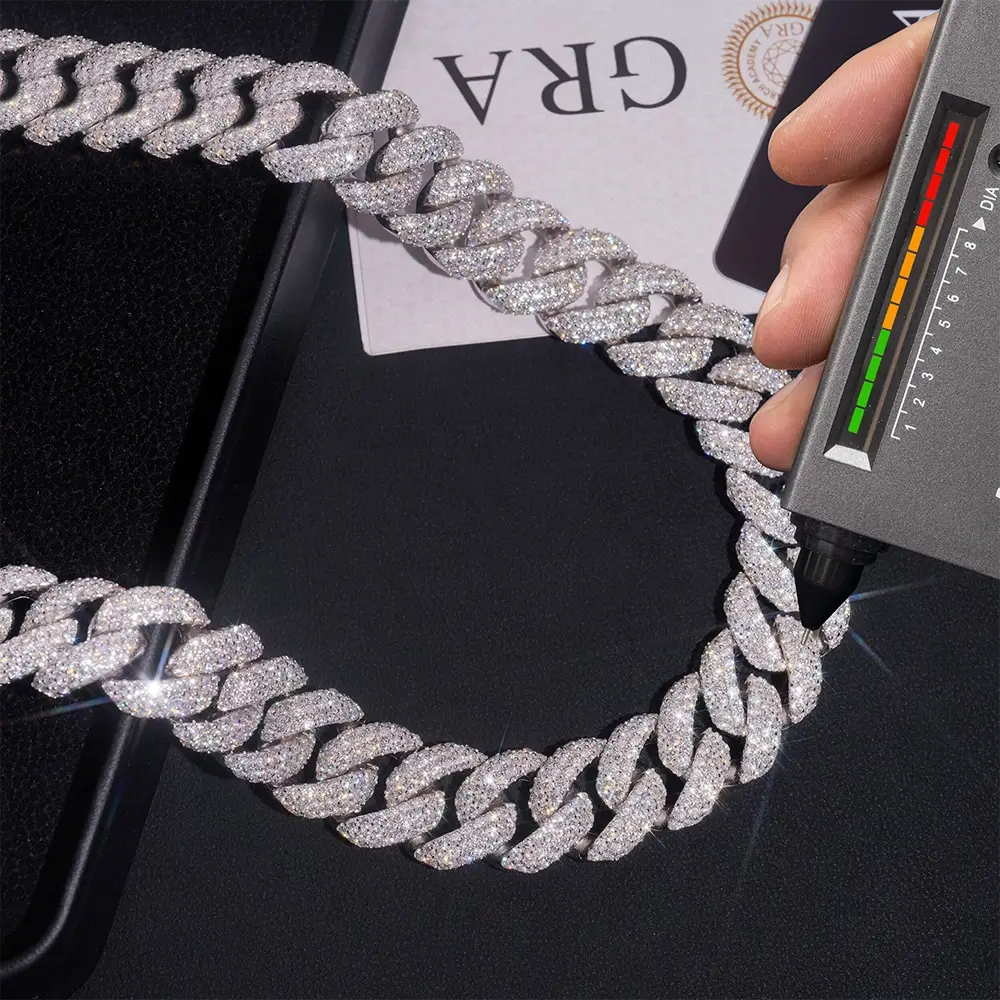 Iced out Cuban link chain necklace being tested with diamond tester on black surface