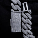Close-up of iced out Cuban link chain with diamond detailing on black background