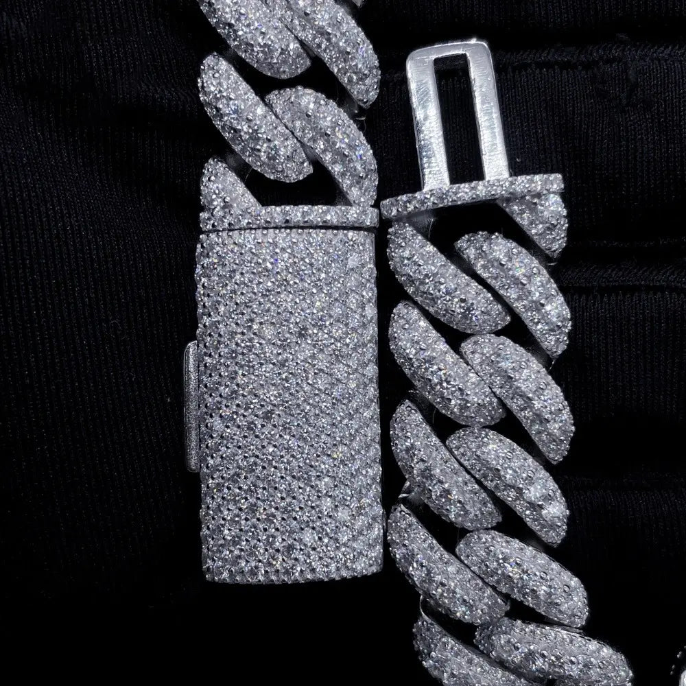 Close-up of iced out Cuban link chain with diamond detailing on black background