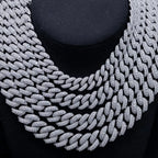Layered iced out Cuban link chain necklaces with sparkling stones on black display