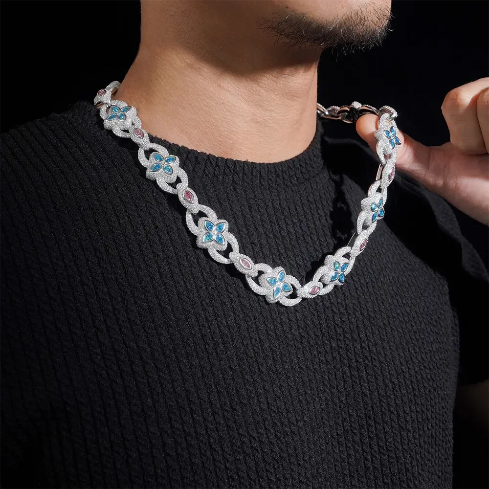 Man wearing a silver iced-out chain necklace with blue and pink gemstone accents Main image