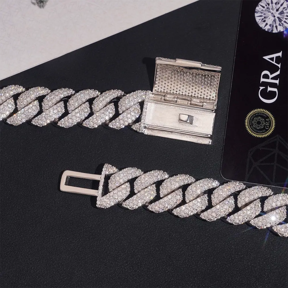 Iced out Cuban link bracelet with diamond accents and box clasp on black surface