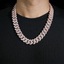 Iced out Cuban link chain necklace with clear stones on a person wearing a black shirt